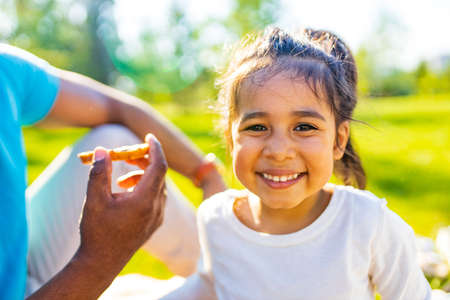 Happy little girl enjoying picnic in natureの写真素材
