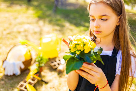 teenager girl in black apron gardening in the backyard gardenの写真素材