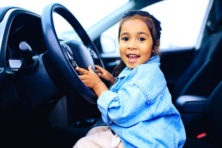 happy child girl in car going on a summer vacation tripの写真素材