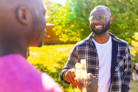 two best mixed race friends having picnic together in summer park outdoors