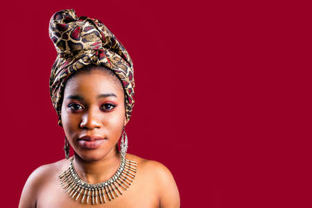 glamour dark skin woman wrapped on turban in studio in red background