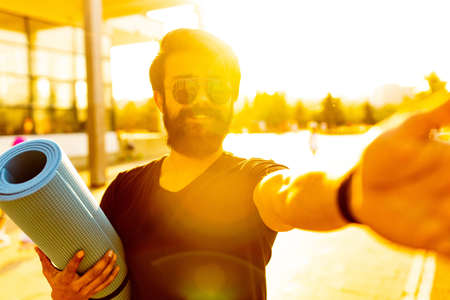 hispanic man in black cotton t-shirt ready to yoga at sunset in summer park outdoor golden lightsの写真素材