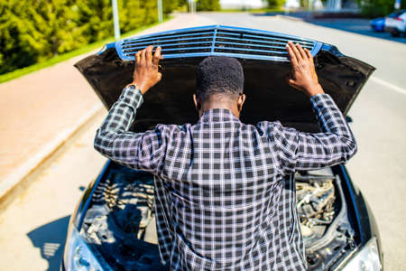 latin hispanic stressed man having trouble with his broken car outdoors