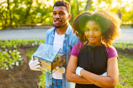 afro american couple gardening outdoors at sunset sunny spring dayの写真素材