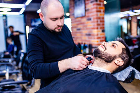 arabic handsome bearded man getting haircut at barbershop
