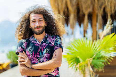 mixed race man with curly long hair outdoors ar sunny dayの写真素材