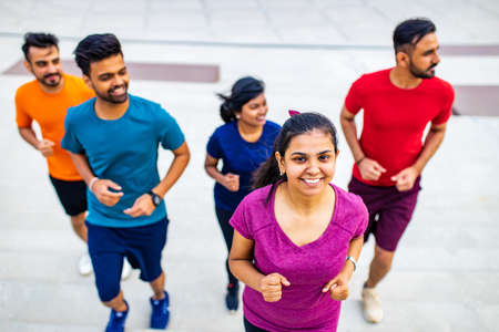 eastern ethnic people exercising together outdoor on sun lightの写真素材