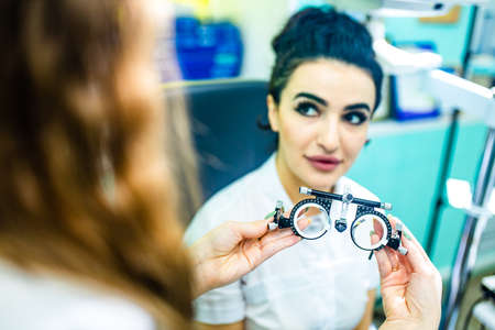italian black curly haired woman in white coat sale a glasses in storeの写真素材