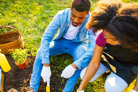 afro american couple gardening outdoors at sunset sunny spring dayの写真素材