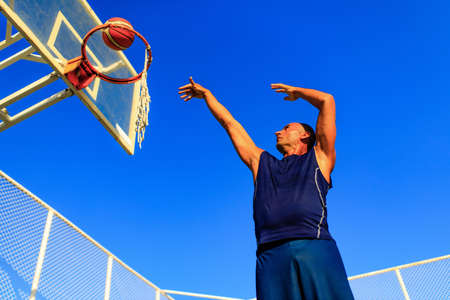 turkish man playing basket ball outdoor in summer day blue sky backgroundの写真素材