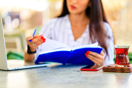 Image of happy asian woman using laptop while sitting at cafe