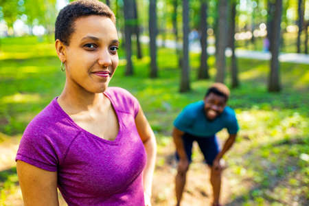 Fit young tired african american couple in sport activity outdoors runs in morningの写真素材