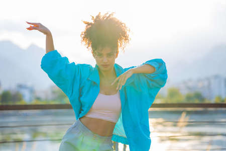 multiracial race curly woman enjoying dance at sunset in beachの写真素材