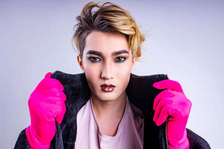 Portrait of stylish fashion man confident and self-acceptance with his gender identity in studio white backgroundの写真素材