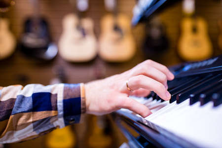 redhair ginger beard man is playing on piano in music storeの写真素材