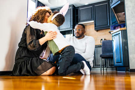happy afro american people in bunny ears celebrate in modern big cozy houseの写真素材