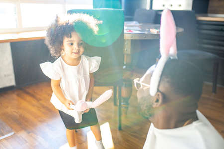 authentic ethnic multicultural people wearing bunny ears in living room day sunlight