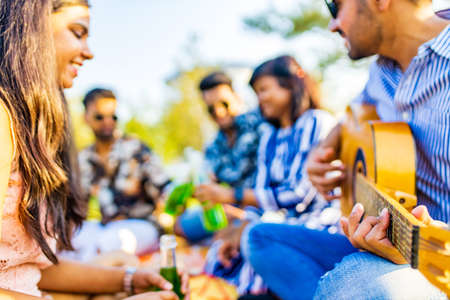multiethnic people spending time together playing guitarの写真素材
