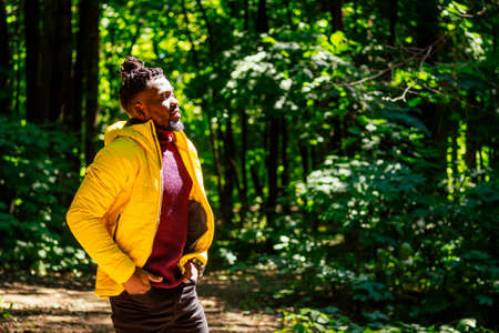 african american man in yellow jacket with a hood and dreadlocks pigtails