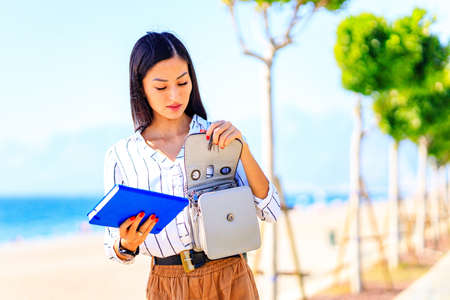 Image of busy asian woman outdoors at sunny summer dayの写真素材