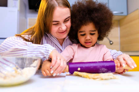 happy multiethnic family cooking pastry together at kitchenの写真素材