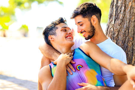 Happy gay couple spending time together in sunny day in green parkの写真素材