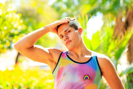 Handsome man in colorful shirt with rainbow badge outdoorの写真素材