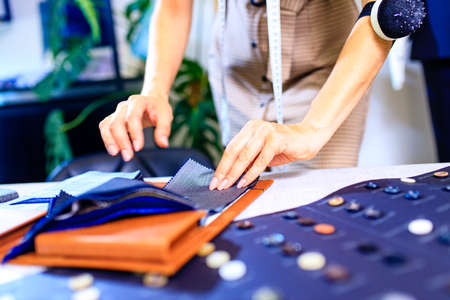 dressmaker woman working with color samples for selection new clothing collection