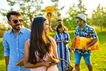 group of four best friends in the park having picnic on a sunny eveningの写真素材
