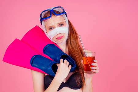 redhaired ginger woman wearing water glasses scuba mask and wrapped and black swimming suit. Her...