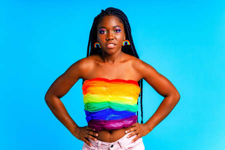 young woman wearing colorful blouse standing isolated over blue background, lgbt conceptの写真素材