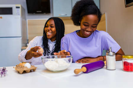 happy african american couple in love making a cake at home