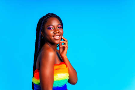 african american woman with gorgeus bright color make up feels proud and self confident in blue wall...