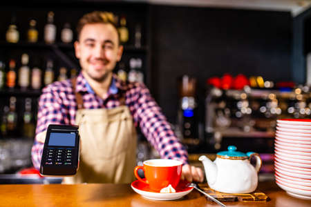 paying by credit card at cafe concept Customer paying for order with a smart phone contactless...