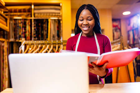 authentic ethnic africa america sellerwoman working in shop with laptop
