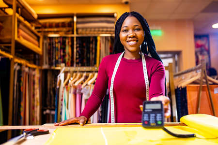 dark skinned business woman salewoman working at textile shop