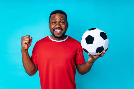 Olympic Games brazilian man wear red sport wear and football glove positive emotions in blue studio backgroundの写真素材