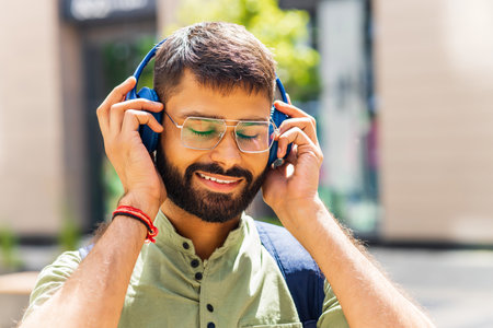 happy latin man listening to music headphones at the cityの写真素材