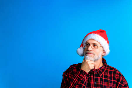 Handsome senior bearded man holding gift box and wish a Merry Christmas and a happy new yearの写真素材