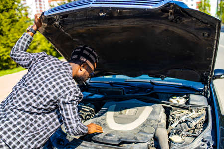 latin hispanic stressed man having trouble with his broken car outdoors