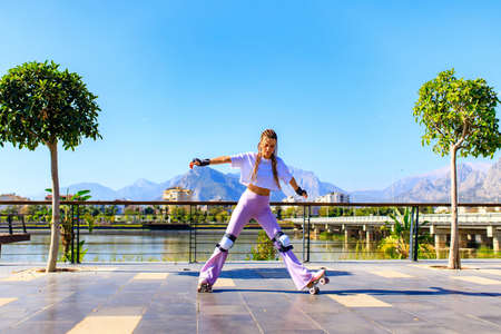 Portrait of beautiful blonde teenager girl with cool pigtails , white t-shirt and flared pink pants...