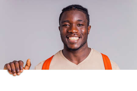 african american man student with backpack in studio smiling at the camera with a white smile