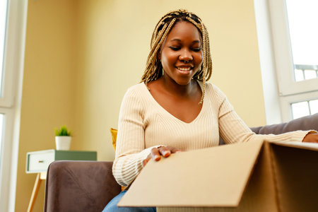 african american woman packing things in a box for movingの写真素材