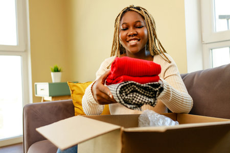 african american woman packing things in a box for movingの写真素材