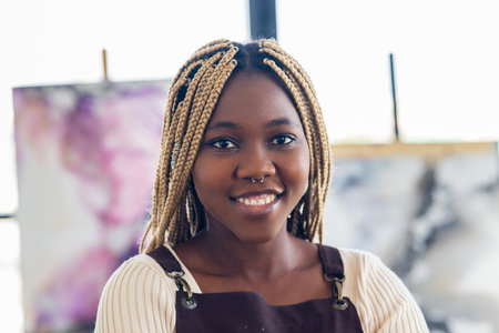 brazilian woman with dreadlocks in white blouse in art studioの写真素材