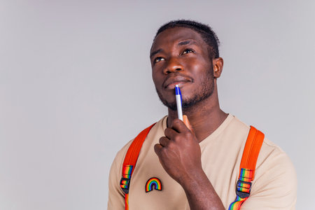 hispanic student man with rainbow badge on t-shirt in studio isolate