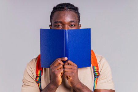 african american man student with backpack in studio smiling at the camera with a white smileの写真素材