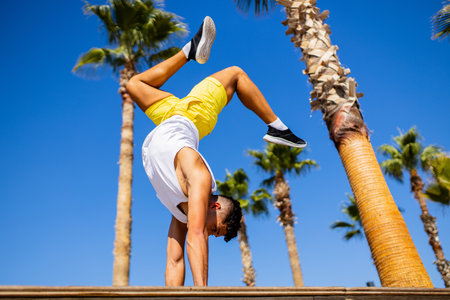 young modern ballet dancer doing tricks in summer beach sunny