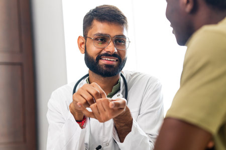 Portrait of indian man doctor talking to patient on consultationの写真素材