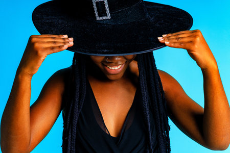 afro american woman with pigtails dreadlocks wear black dress and witch hat costume cone headwear...